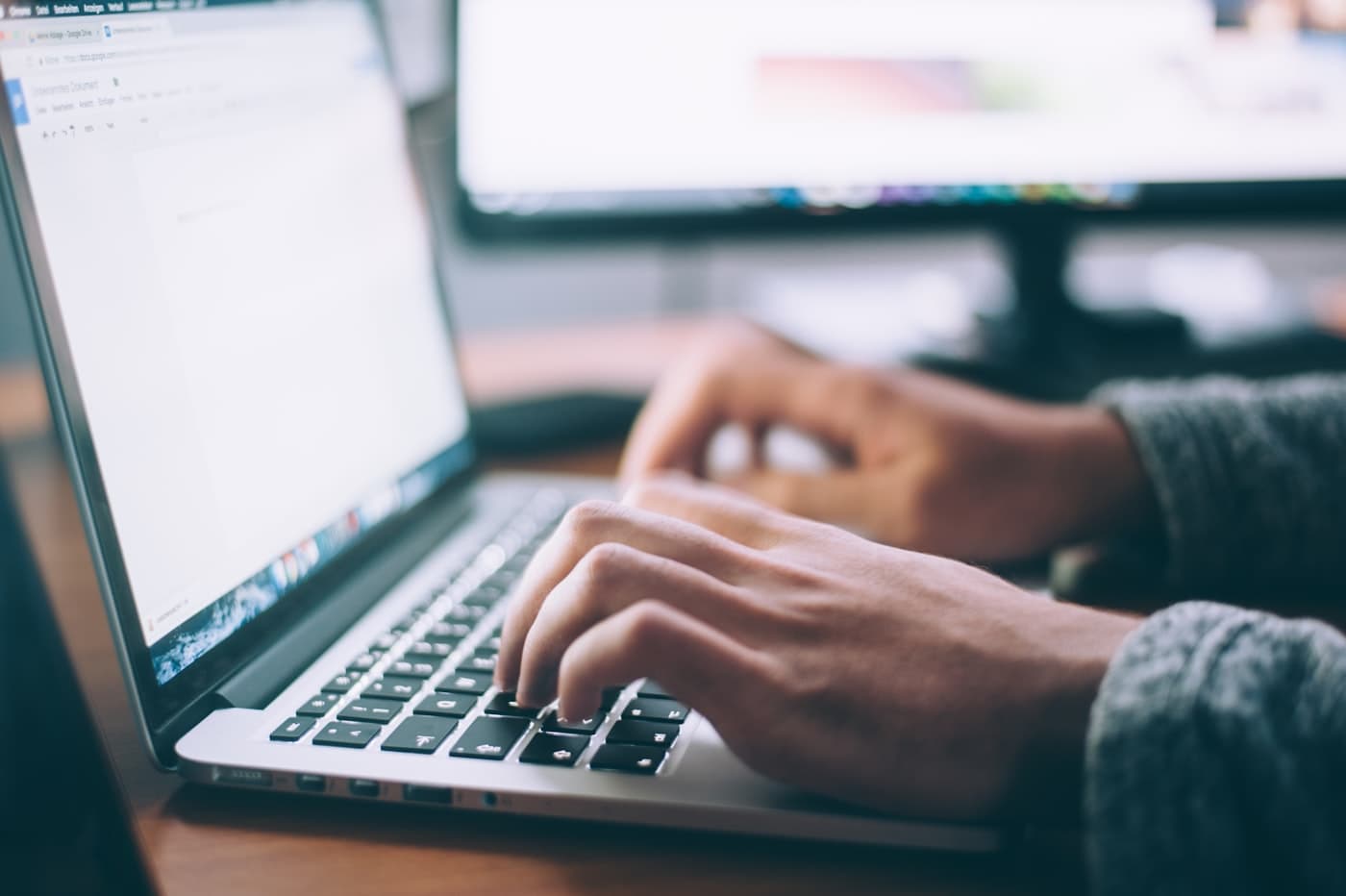 Person writing on a laptop, drafting long-form content