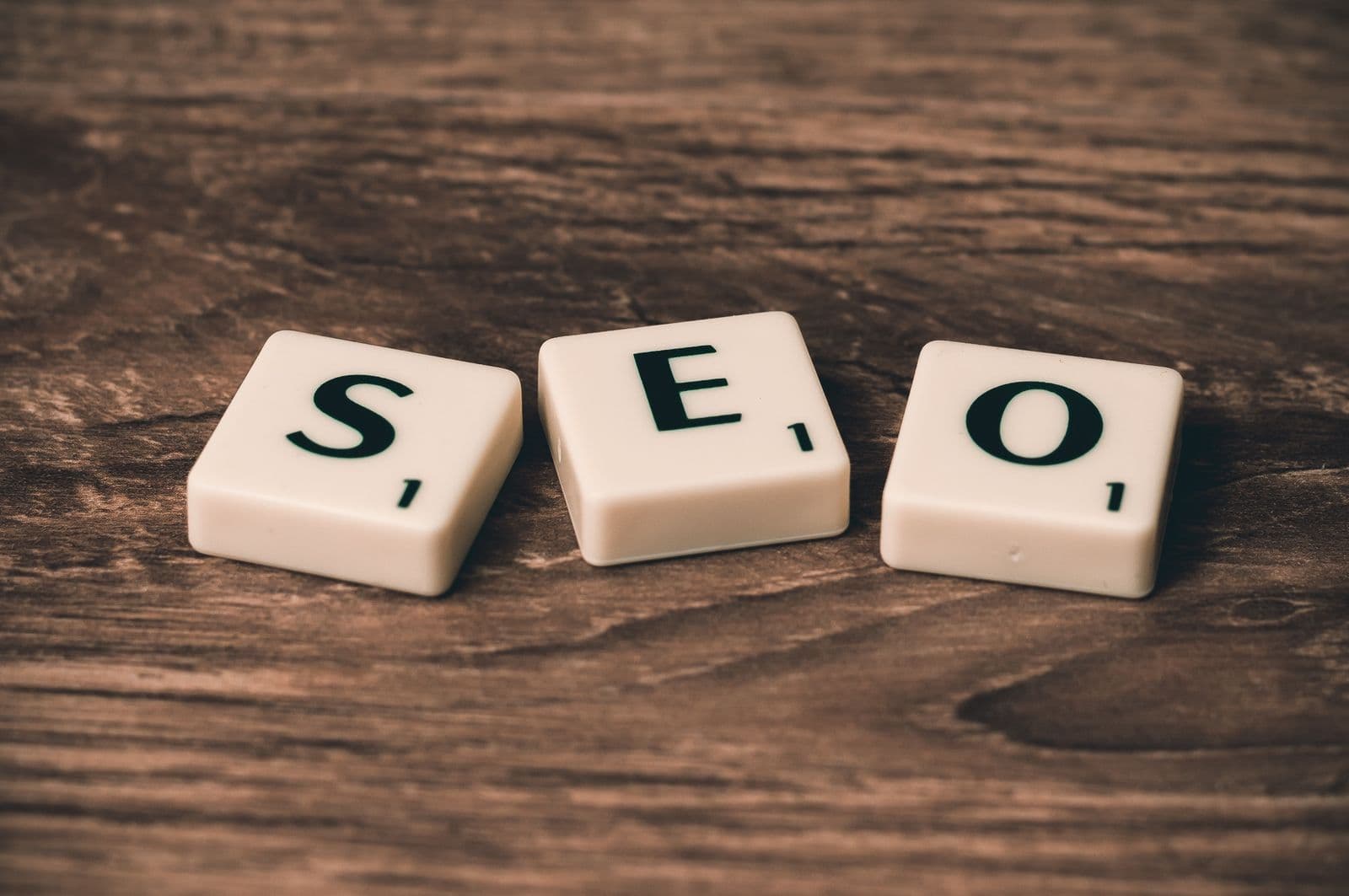 Letter tiles spelling SEO on a wooden desk